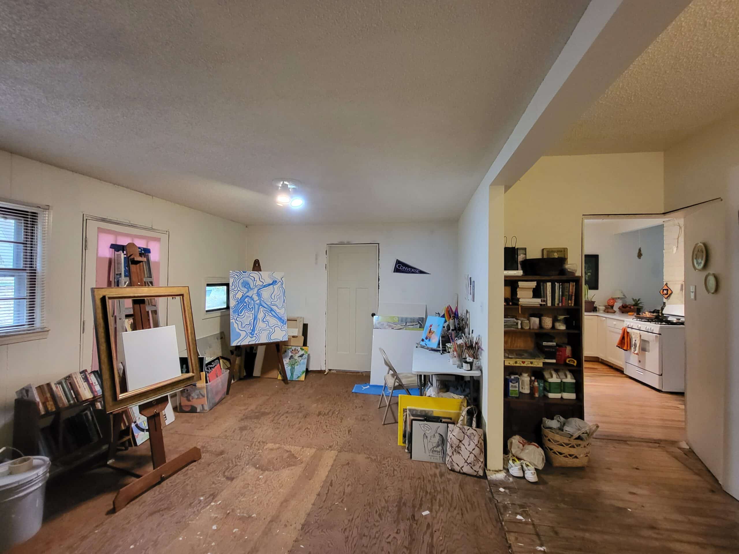 Bright artist studio with sketch easel and shelves